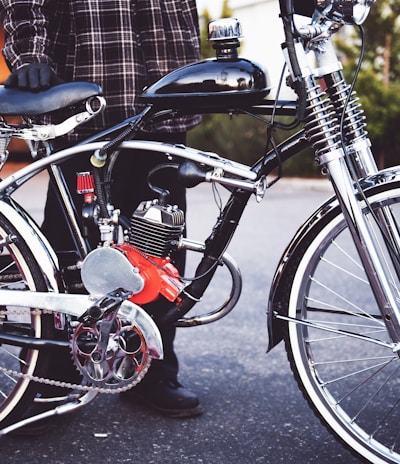 person holding black motorized bicycle